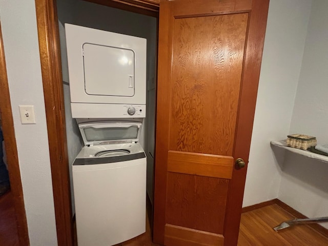 402 Brewster St, Harvey, ND 58341 - washroom with wood finished floors, stacked washer / drying machine, laundry area, and baseboards