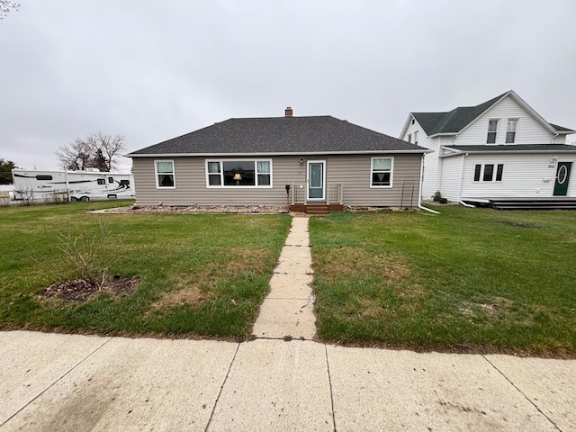 402 Brewster St, Harvey, ND 58341 - view of front facade with a chimney, a front lawn, and roof with shingles