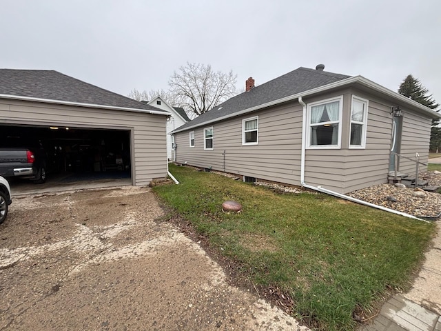 402 Brewster St, Harvey, ND 58341 - view of home's exterior featuring concrete driveway, a chimney, roof with shingles, a lawn, and a garage