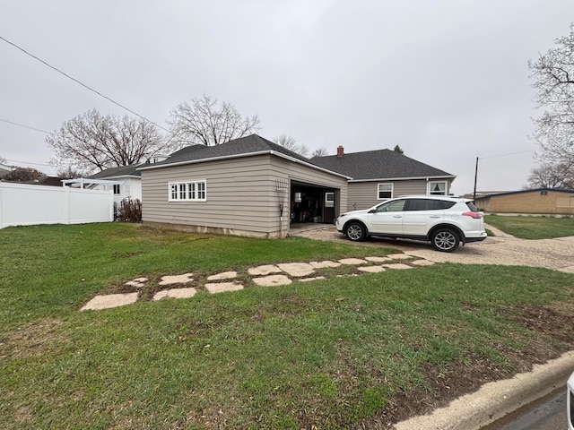 402 Brewster St, Harvey, ND 58341 - view of side of home with a garage, fence, driveway, and a lawn