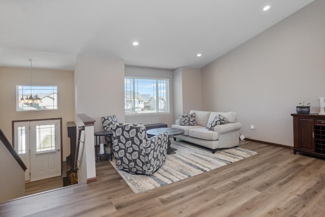 living area featuring baseboards, recessed lighting, wood finished floors, and a chandelier