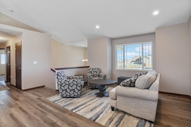 living area with recessed lighting, baseboards, an upstairs landing, and wood finished floors