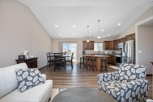 living area with recessed lighting, dark wood finished floors, and vaulted ceiling