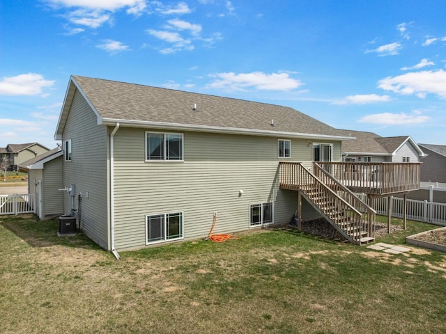 rear view of house with fence, a wooden deck, a yard, and stairway