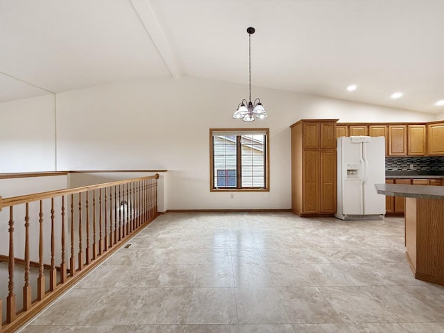 kitchen featuring brown cabinetry, dark countertops, white refrigerator with ice dispenser, lofted ceiling with beams, and an inviting chandelier
