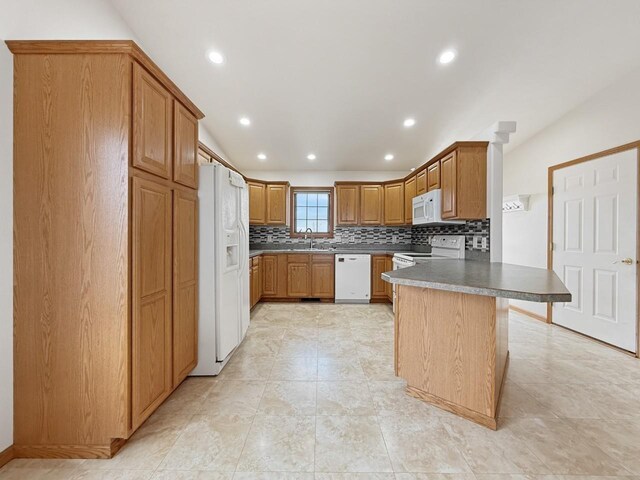 kitchen with a peninsula, recessed lighting, backsplash, and white appliances
