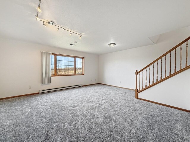 carpeted empty room with track lighting, baseboards, and a baseboard radiator