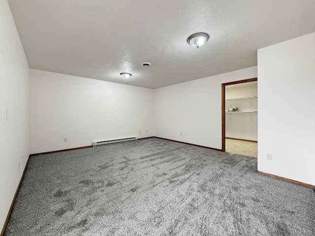 carpeted empty room with a textured ceiling, baseboards, and a baseboard radiator