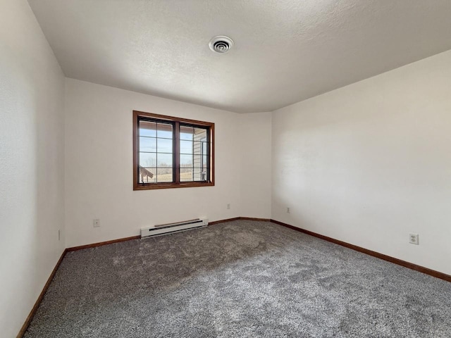 spare room featuring baseboard heating, a textured ceiling, carpet, baseboards, and visible vents