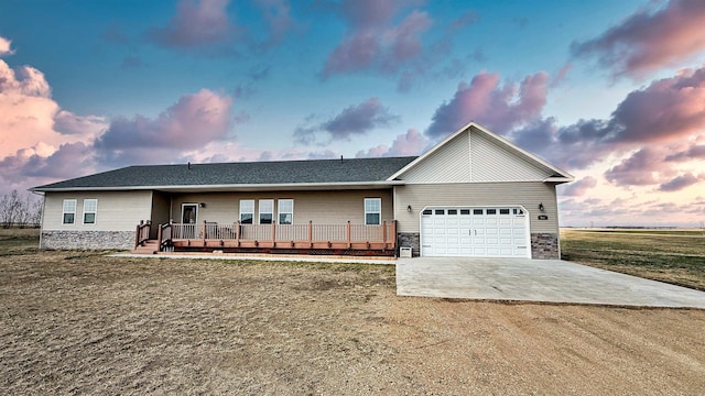 ranch-style house featuring a garage, dirt driveway, a wooden deck, and stone siding
