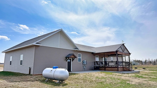 view of side of property featuring a patio, a wooden deck, and central air condition unit