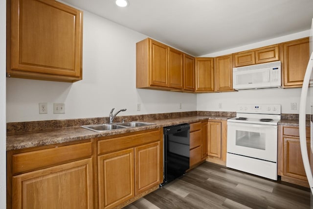 kitchen featuring white appliances, dark countertops, dark wood finished floors, and a sink