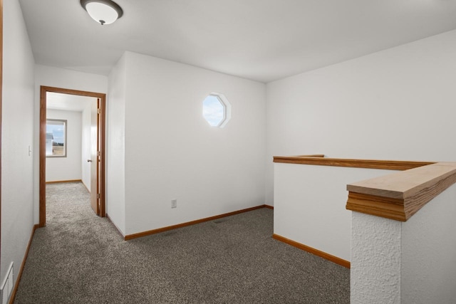 unfurnished room featuring carpet flooring, baseboards, and a wealth of natural light
