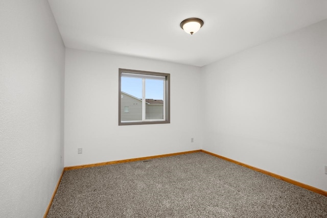 carpeted spare room featuring baseboards