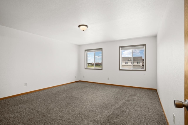 carpeted empty room with baseboards