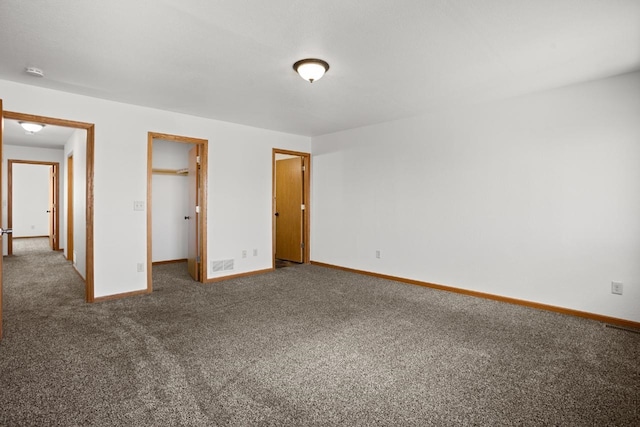 unfurnished bedroom with visible vents, baseboards, a spacious closet, and carpet