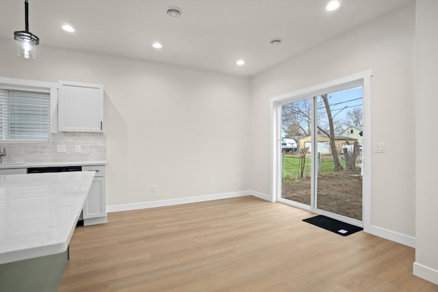 unfurnished dining area featuring recessed lighting, baseboards, and light wood finished floors