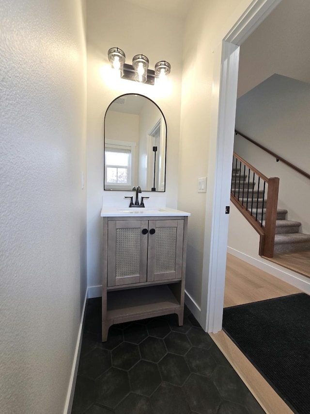 bathroom with baseboards, tile patterned flooring, and vanity