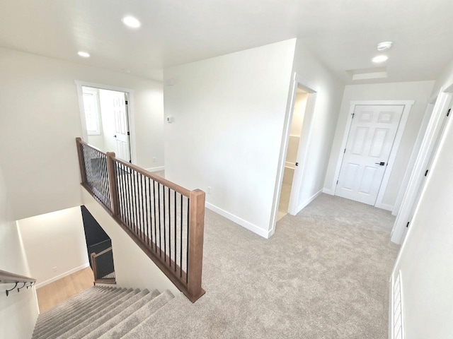 corridor with baseboards, carpet flooring, recessed lighting, and an upstairs landing