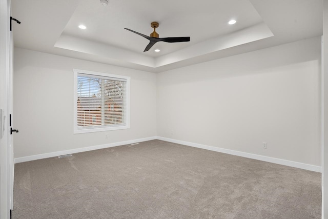 carpeted empty room with baseboards, ceiling fan, a tray ceiling, and recessed lighting