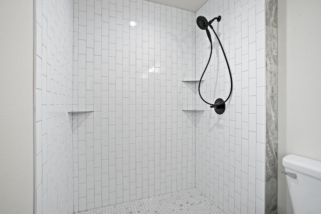 bathroom with toilet and tiled shower