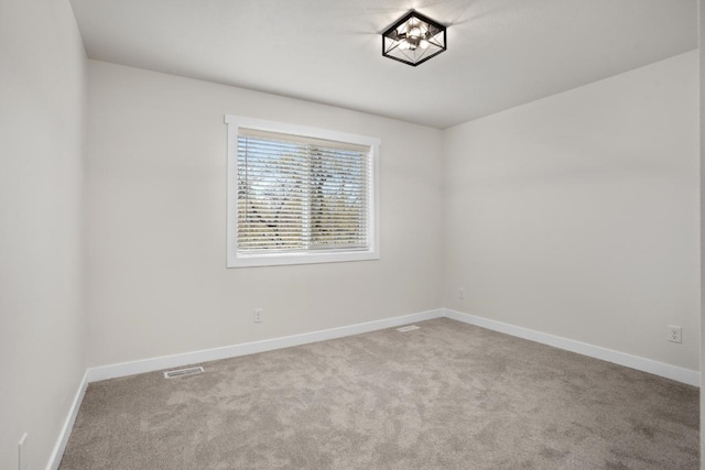 spare room featuring baseboards and carpet