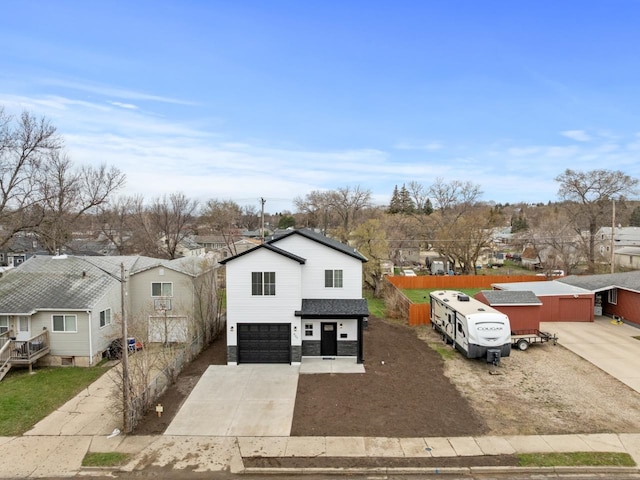 view of front of property featuring concrete driveway, a residential view, and a garage