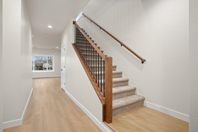 staircase featuring baseboards, recessed lighting, and wood finished floors