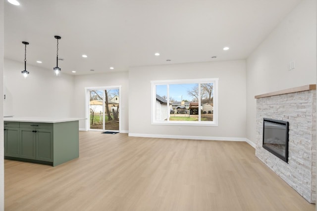 unfurnished living room featuring a fireplace, recessed lighting, baseboards, and light wood-type flooring