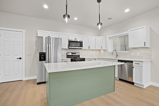 kitchen featuring light wood-type flooring, decorative backsplash, a kitchen island, and stainless steel appliances