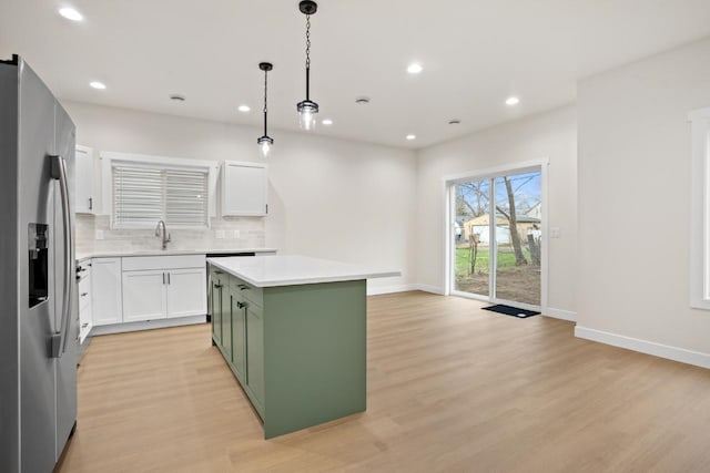 kitchen with decorative backsplash, light wood-style floors, a center island, green cabinetry, and stainless steel fridge with ice dispenser