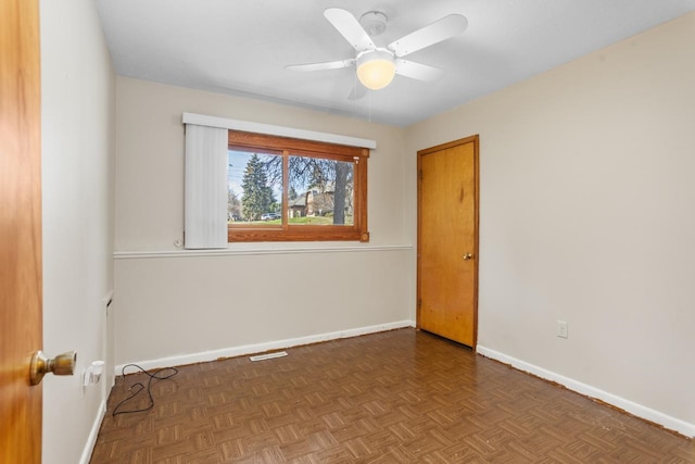 spare room featuring baseboards, visible vents, and ceiling fan