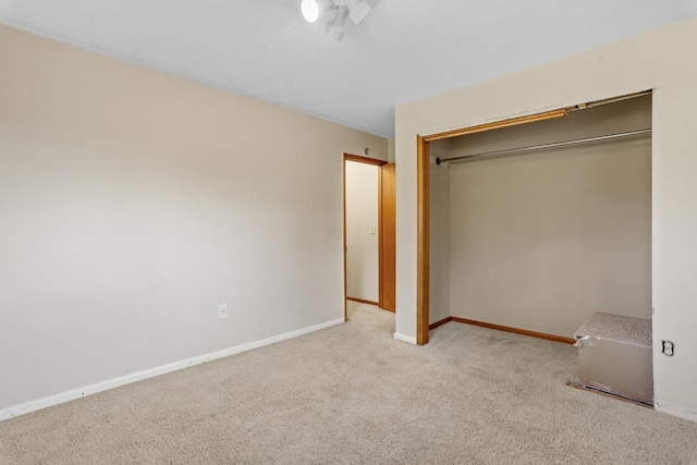 unfurnished bedroom featuring carpet floors, baseboards, and a closet