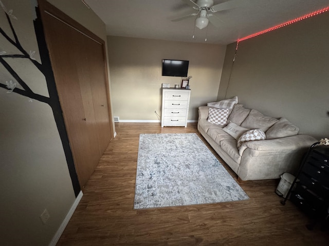 living room with baseboards, ceiling fan, and wood finished floors