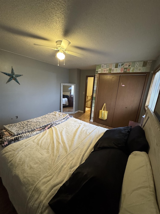 bedroom featuring a closet, a textured ceiling, and ceiling fan