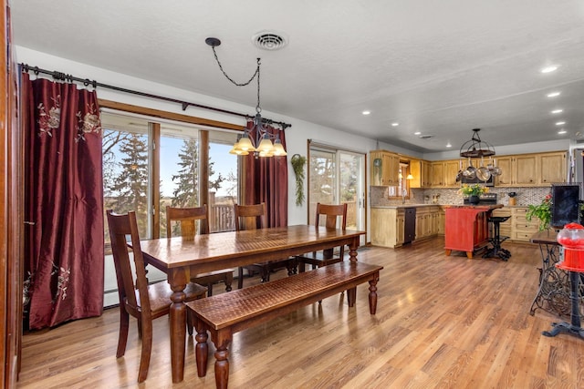 9500 135th Ave, Sawyer, ND 58781 - dining area featuring an inviting chandelier, visible vents, light wood finished floors, and a healthy amount of sunlight