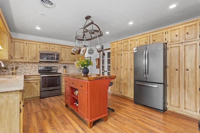 9500 135th Ave, Sawyer, ND 58781 - kitchen featuring a kitchen island, stainless steel appliances, light wood finished floors, and tasteful backsplash