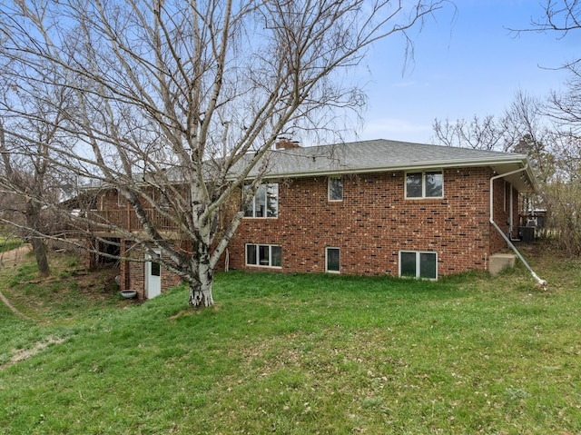 9500 135th Ave, Sawyer, ND 58781 - view of home's exterior featuring central AC unit, a chimney, a yard, and brick siding