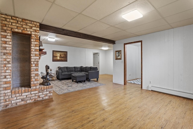 9500 135th Ave, Sawyer, ND 58781 - living room with wood walls, baseboards, baseboard heating, a paneled ceiling, and hardwood / wood-style flooring