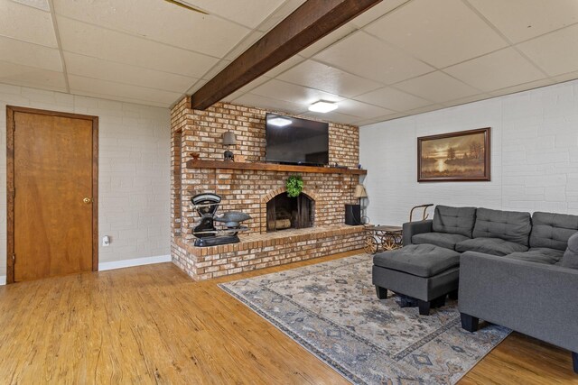 9500 135th Ave, Sawyer, ND 58781 - living area with a brick fireplace, brick wall, a drop ceiling, and wood finished floors