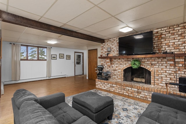 9500 135th Ave, Sawyer, ND 58781 - living area with a baseboard heating unit, wood finished floors, and a paneled ceiling