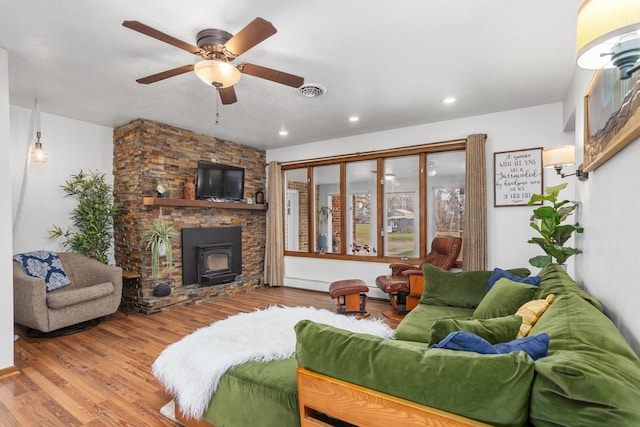 9500 135th Ave, Sawyer, ND 58781 - living room with a wood stove, wood finished floors, ceiling fan, baseboard heating, and recessed lighting
