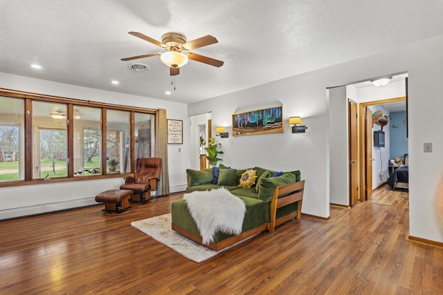 9500 135th Ave, Sawyer, ND 58781 - living room with visible vents, wood finished floors, recessed lighting, a baseboard heating unit, and a ceiling fan