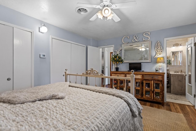 9500 135th Ave, Sawyer, ND 58781 - bedroom featuring multiple closets, a ceiling fan, wood finished floors, ensuite bathroom, and visible vents