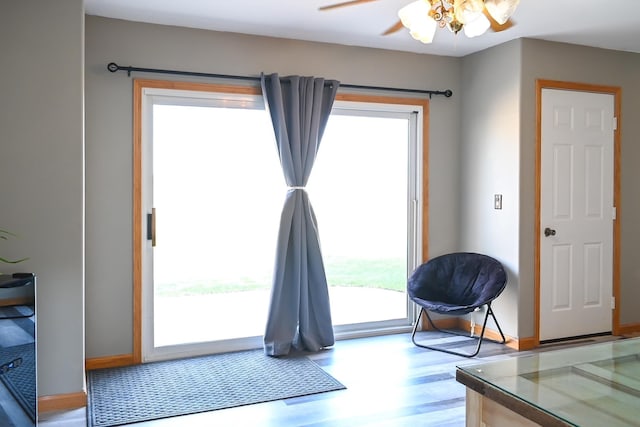 interior space with baseboards, ceiling fan, and light wood-style flooring