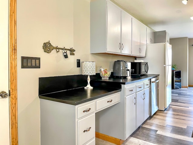 kitchen featuring white cabinets, dark countertops, black microwave, light wood-style floors, and dishwasher