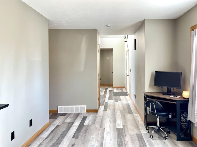 office with baseboards, wood finished floors, and visible vents