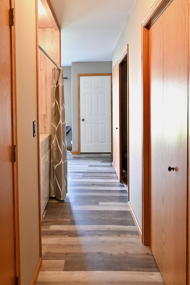 hall with baseboards and wood finished floors