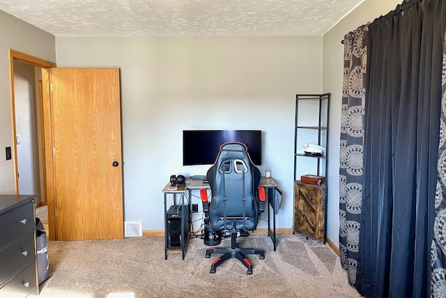 office area featuring baseboards, carpet, a textured ceiling, and visible vents