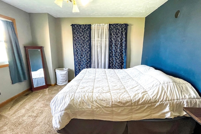 carpeted bedroom featuring baseboards and a ceiling fan